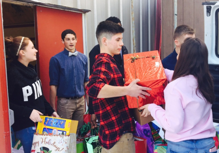 Group of teens delivering donation bags to a home